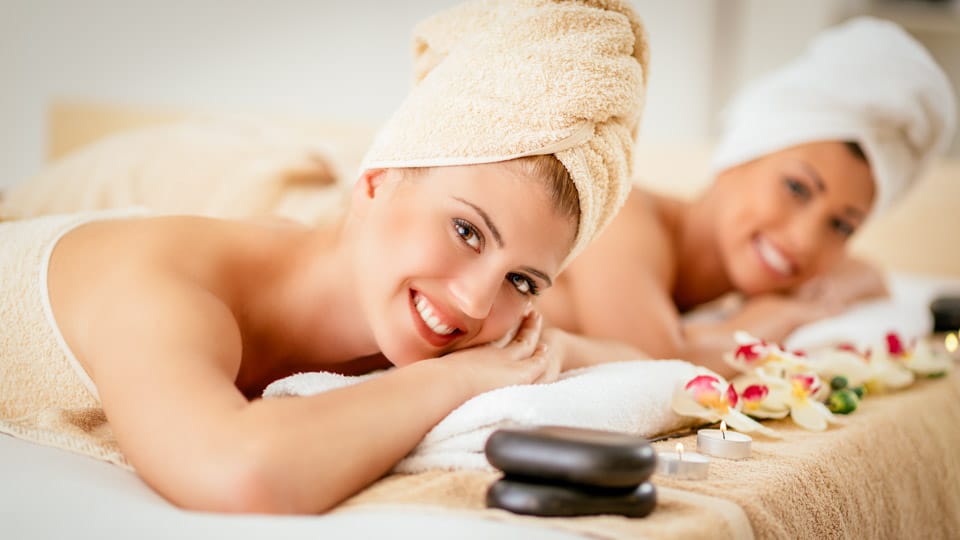 2 women smiling and getting massaged